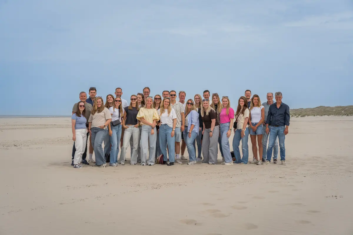 De collega's van Wente samen op het strand