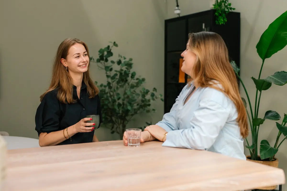 Twee collega's van Makelaardij Faber in gesprek aan tafel