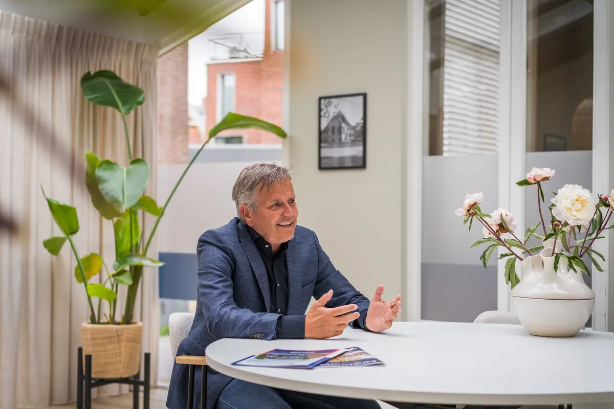 Een adviseur van Makelaardij Faber in gesprek aan tafel op kantoor