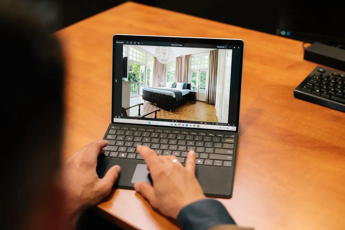 Laptop met de foto van een slaapkamer op het scherm